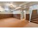 Spacious basement featuring carpeted flooring, wood paneling, and access to the stairway at 6900 Avrum Dr, Denver, CO 80221