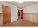 Spacious unfinished basement area with wood paneling halfway up the walls, offering plenty of potential at 6900 Avrum Dr, Denver, CO 80221