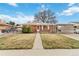 Charming brick home featuring a well-maintained front yard and a convenient carport at 6900 Avrum Dr, Denver, CO 80221