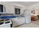 Vintage kitchen with white cabinetry, blue countertops, and a view into the adjacent living room at 6900 Avrum Dr, Denver, CO 80221