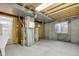 Unfinished basement with exposed ceiling, utility sink and heater at 11585 Decatur St # B, Denver, CO 80234