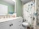 Well-lit bathroom featuring a white vanity with marble countertop and floral shower curtain at 6511 Shea Pl, Highlands Ranch, CO 80130