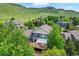 Back of the home featuring a spacious wooden deck perfect for outdoor entertaining and a green, lush backdrop at 18967 W 54Th Ln, Golden, CO 80403