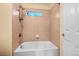 Cozy bathroom with shower over tub, neutral tile, and small window at 18967 W 54Th Ln, Golden, CO 80403