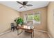 Well-lit home office with a ceiling fan, carpet floors, large window, and a wooden desk at 18967 W 54Th Ln, Golden, CO 80403