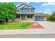 Inviting two-story home featuring a covered front porch, manicured lawn, and a two-car garage at 18967 W 54Th Ln, Golden, CO 80403