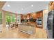 Open kitchen with stainless steel appliances, island, wood cabinetry, breakfast nook, and backyard deck access at 18967 W 54Th Ln, Golden, CO 80403