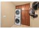 Convenient laundry area features a stacked washer/dryer unit and built-in storage cabinets for organization at 18967 W 54Th Ln, Golden, CO 80403