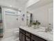 Bathroom with a marble vanity top, double sinks, and tile walls at 5445 Verbena St, Denver, CO 80238