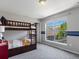 Bright bedroom featuring a bunk bed and a large window with neighborhood views at 5445 Verbena St, Denver, CO 80238