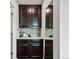 Hallway with beverage station featuring dark cabinets, light granite counters and mosaic tile backsplash at 5445 Verbena St, Denver, CO 80238