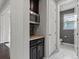Hallway featuring a convenient beverage station and a pristine white-tiled bathroom at 5445 Verbena St, Denver, CO 80238
