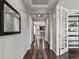 Elegant hallway with hardwood floors, tray ceilings, and a view into other rooms at 5445 Verbena St, Denver, CO 80238