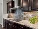 Gourmet kitchen featuring granite countertops, stainless steel hood vent and sleek dark brown cabinetry at 5445 Verbena St, Denver, CO 80238
