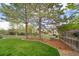 Lush backyard featuring a well-manicured lawn, trees, and a wooden fence at 9548 La Quinta Dr, Lone Tree, CO 80124