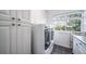 Bright laundry room with plenty of cabinet space, modern appliances and a large window for natural light at 9548 La Quinta Dr, Lone Tree, CO 80124