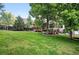 Expansive, well-maintained lawn with mature trees, lush landscaping, and a charming wooden deck at 4674 Winona Pl, Broomfield, CO 80020