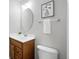 Cozy powder room featuring framed art, a wooden vanity, and an oval mirror at 4674 Winona Pl, Broomfield, CO 80020