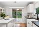Kitchen with deck access features black countertops, island and farmhouse sink at 4674 Winona Pl, Broomfield, CO 80020