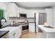 Charming kitchen with white cabinets, stainless steel appliances, and a modern backsplash at 4674 Winona Pl, Broomfield, CO 80020