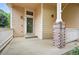 Inviting front porch area with brick and beam columns and a storm door at 4674 Winona Pl, Broomfield, CO 80020
