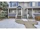 Townhome entrance with stairs and snowy landscaping at 19249 E Carolina Dr # 106, Aurora, CO 80017