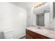 Bathroom with a granite vanity, decorative mirror, and a shower with gray tile at 875 S Quebec St # 21, Denver, CO 80247