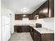 Functional kitchen featuring tile floors, dark cabinets, granite countertops, and modern appliances at 875 S Quebec St # 21, Denver, CO 80247