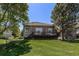 A brick home's backyard offers an attractive deck area with lawn and mature landscaping at 6500 W Mansfield Ave # 39, Denver, CO 80235