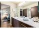 Modern bathroom featuring vanity with double sinks and a view into a bedroom at 6500 W Mansfield Ave # 39, Denver, CO 80235