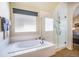 Bright bathroom with a soaking tub, separate glass shower, and large window at 6500 W Mansfield Ave # 39, Denver, CO 80235