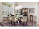 Stylish dining room showcasing a glass table, modern lighting, and a classic display cabinet for elegant dining at 6500 W Mansfield Ave # 39, Denver, CO 80235