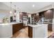 Spacious kitchen boasts stainless steel appliances, wooden cabinetry, bright lighting, and a functional island cooktop at 6500 W Mansfield Ave # 39, Denver, CO 80235