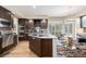 Modern kitchen featuring wood cabinets, stainless steel appliances, cooktop island, and colorful decorative rug at 6500 W Mansfield Ave # 39, Denver, CO 80235