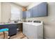 Well-equipped laundry room with modern washer/dryer, ample counter space, overhead storage, and natural light at 6500 W Mansfield Ave # 39, Denver, CO 80235