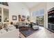Bright living room featuring hardwood floors, high ceilings, and large windows with sliding doors to the backyard at 6500 W Mansfield Ave # 39, Denver, CO 80235