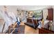 Bright room featuring a treadmill, built-in shelving, and an easel at 6500 W Mansfield Ave # 39, Denver, CO 80235