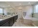 Luxurious bathroom featuring double sinks, a soaking tub, and a separate shower at 6335 E 143Rd Dr, Thornton, CO 80602