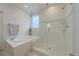 Bright bathroom featuring a separate soaking tub and glass-enclosed shower at 6335 E 143Rd Dr, Thornton, CO 80602