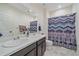 Bathroom featuring a double sink vanity and shower with decorative curtain at 6335 E 143Rd Dr, Thornton, CO 80602