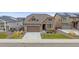 Charming two-story home featuring stone accents, a well-manicured lawn, and an attached two-car garage at 6335 E 143Rd Dr, Thornton, CO 80602