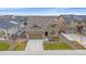 Charming two-story home featuring a stone facade, well-maintained lawn and attached garage with a paved driveway at 6335 E 143Rd Dr, Thornton, CO 80602