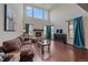 Inviting living room featuring a stone fireplace, hardwood floors, and large windows with lots of natural light at 6335 E 143Rd Dr, Thornton, CO 80602
