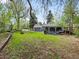 Landscaped backyard features a covered patio, fire pit, and mature trees for privacy at 1580 Youngfield St, Lakewood, CO 80215