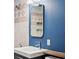 Bathroom features a modern sink, mirror, and stylish tile work against blue walls at 1580 Youngfield St, Lakewood, CO 80215