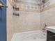 Bathroom tub-shower combo with beige tile and wall-mounted accessories offers a clean and practical design at 1580 Youngfield St, Lakewood, CO 80215