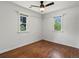 Bedroom featuring hardwood floors, two windows, a ceiling fan, and crisp, white walls at 1580 Youngfield St, Lakewood, CO 80215