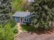 Inviting front exterior features a red door, manicured lawn, and mature trees offering shade at 1580 Youngfield St, Lakewood, CO 80215