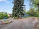 Cozy house with mature trees and a spacious gravel driveway with unique garden planter at 1580 Youngfield St, Lakewood, CO 80215