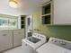 Functional laundry room boasts built-in storage cabinets and modern washer and dryer for convenience at 1580 Youngfield St, Lakewood, CO 80215